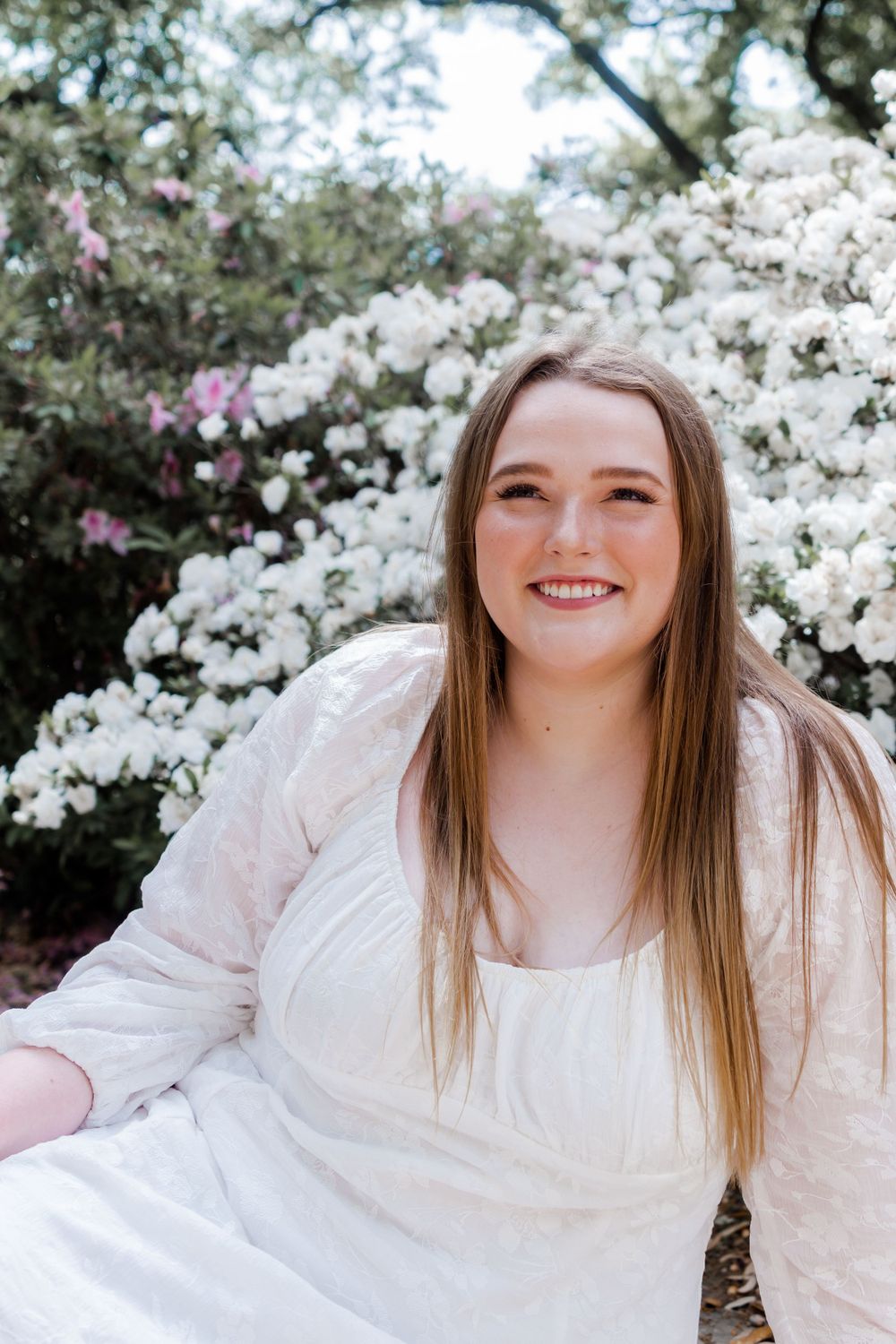 Spring portrait captured in front of blooming white magnolia flowers.