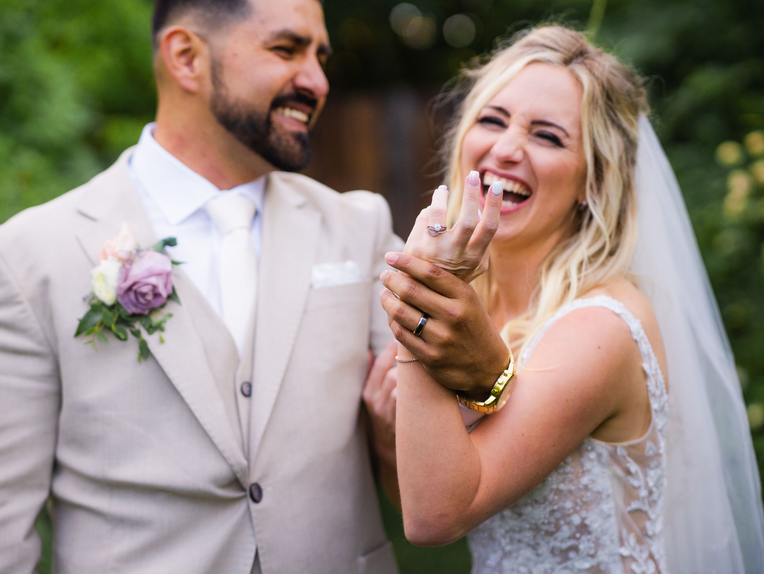 A joyful bride and groom share a candid laughing moment together on their wedding day at Las Cascadas.
