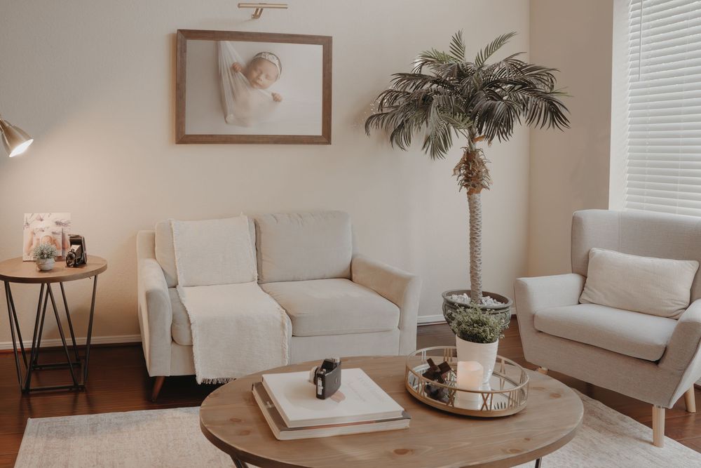 Panoramic view of a modern living room with neutral decor featuring white furniture and beige accents.