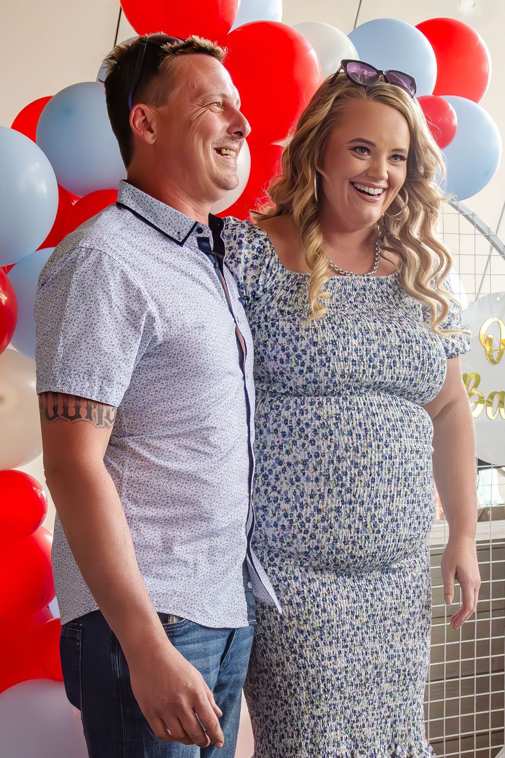 Couple sharing happy moment in front of festive balloon display.