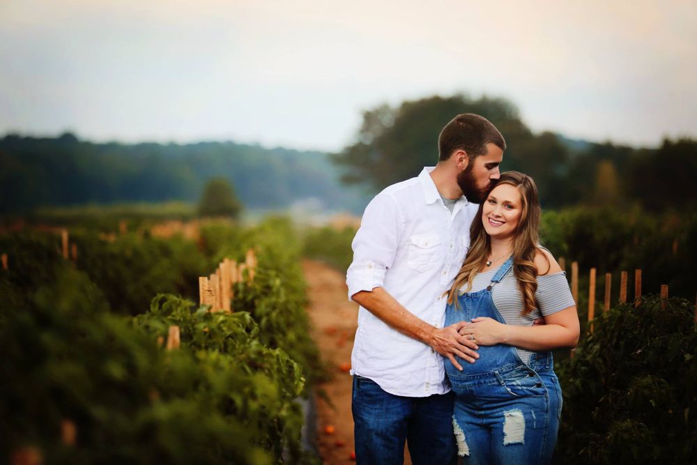 Romantic couple embrace in vineyard during golden hour sunset.