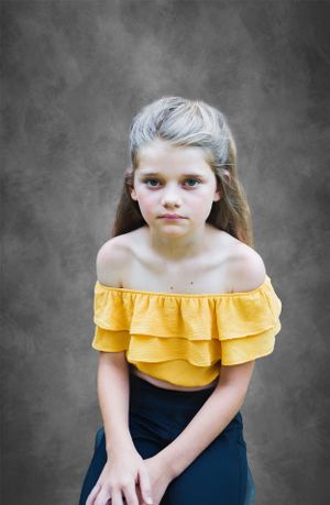 Dance portrait session featuring yellow costume against dark gray background.
