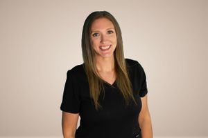 Studio portraits of woman in black shirt against neutral background.