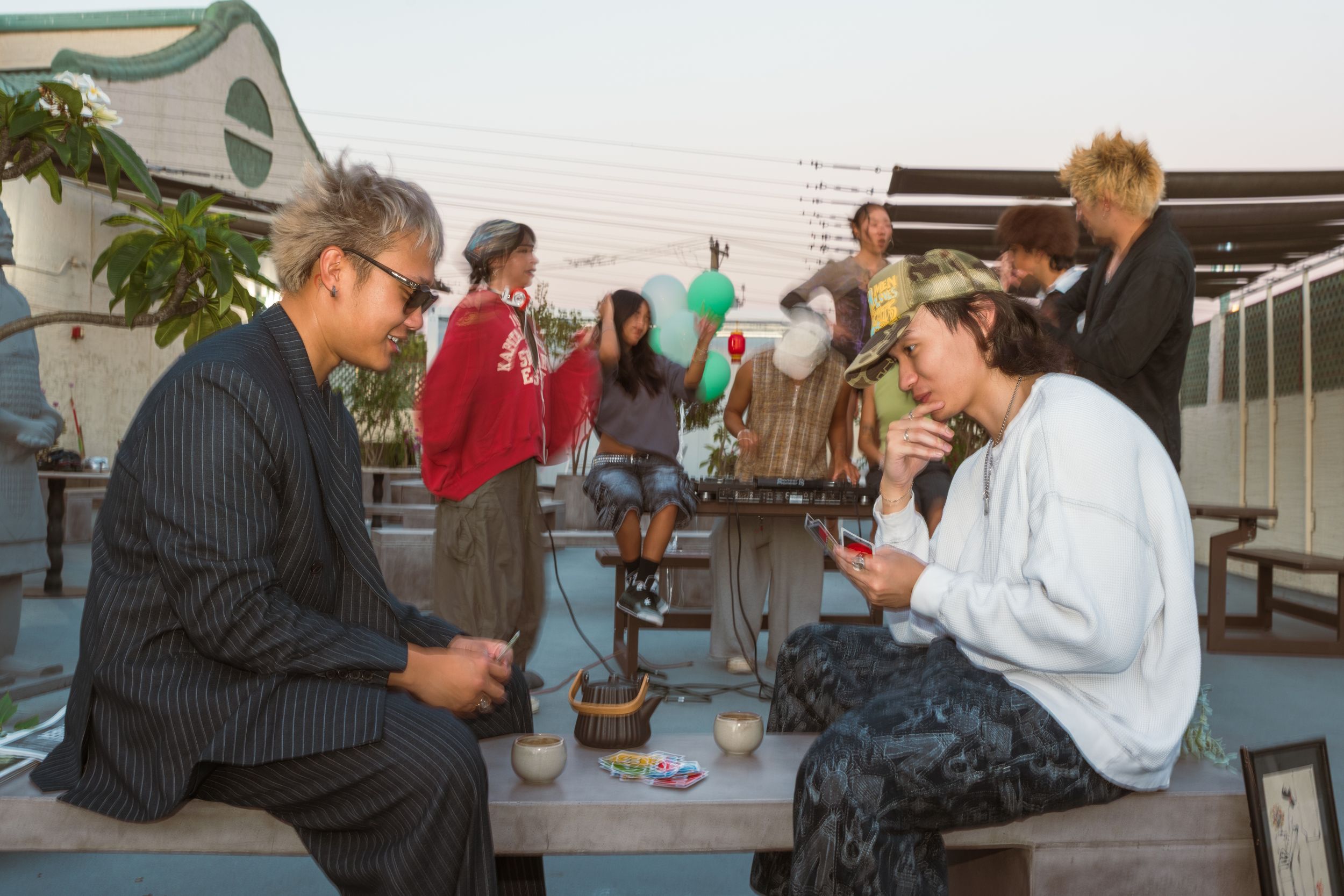 Students in a study group work together at an outdoor table on a patio during a sunny day.