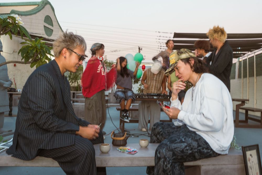 Students in a study group work together at an outdoor table on a patio during a sunny day.