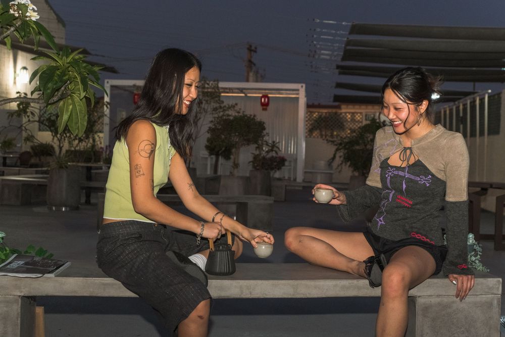 Friends enjoy socializing and playing board games at night in an outdoor setting.