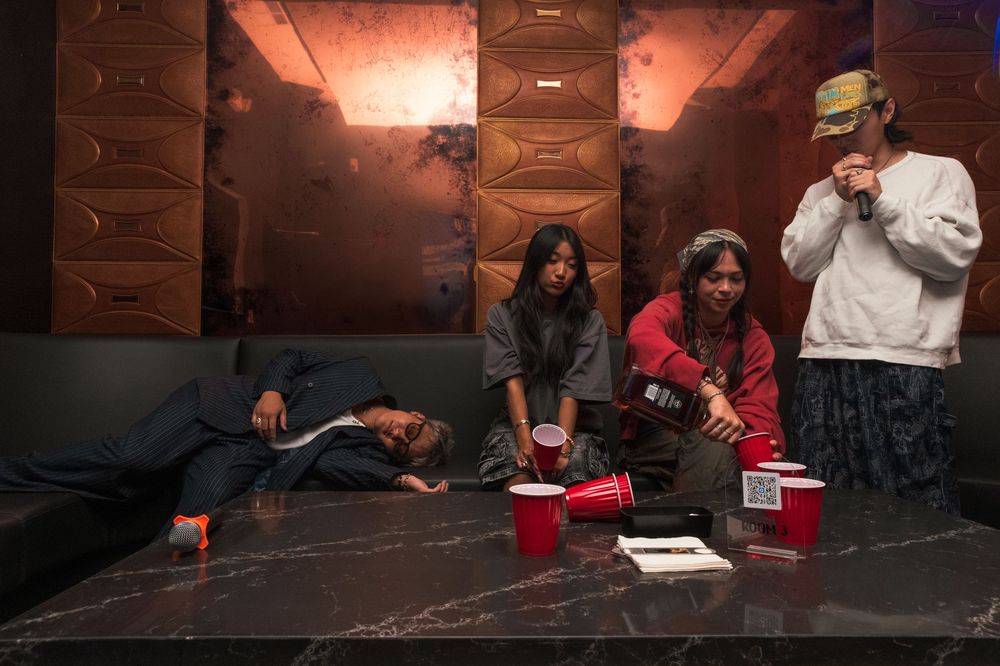People playing games and socializing in a dimly lit room with red cups and casual atmosphere.