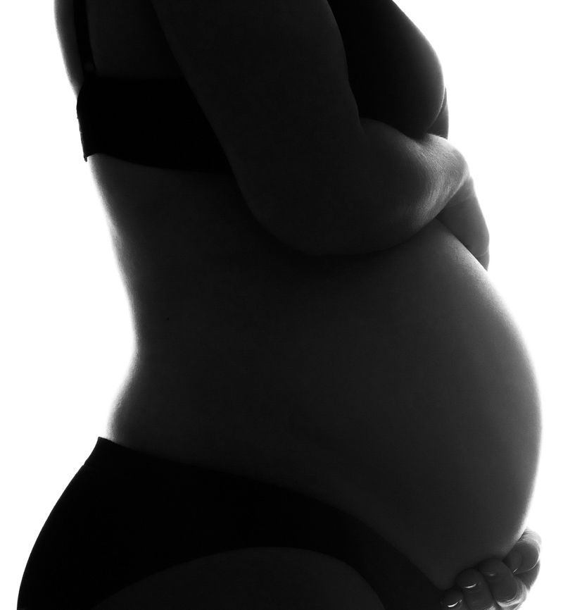 Artistic portrait with dramatic lighting against black background.