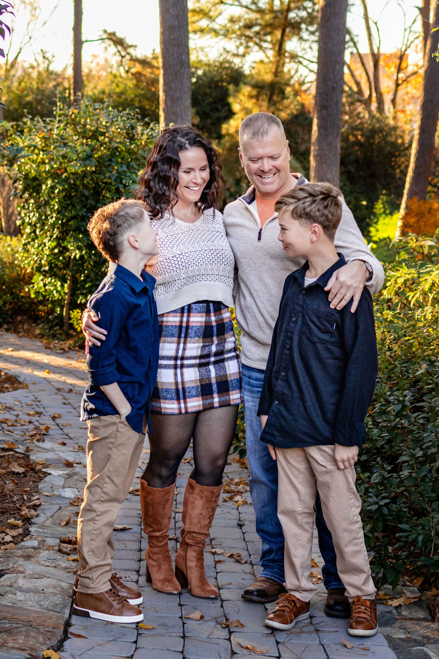 a family smiling at each other at a garden