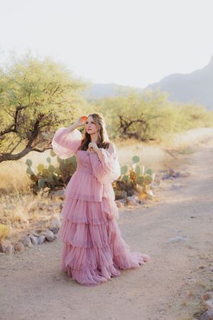 A pink tulle dress creates dreamy movement in a desert setting with cacti.