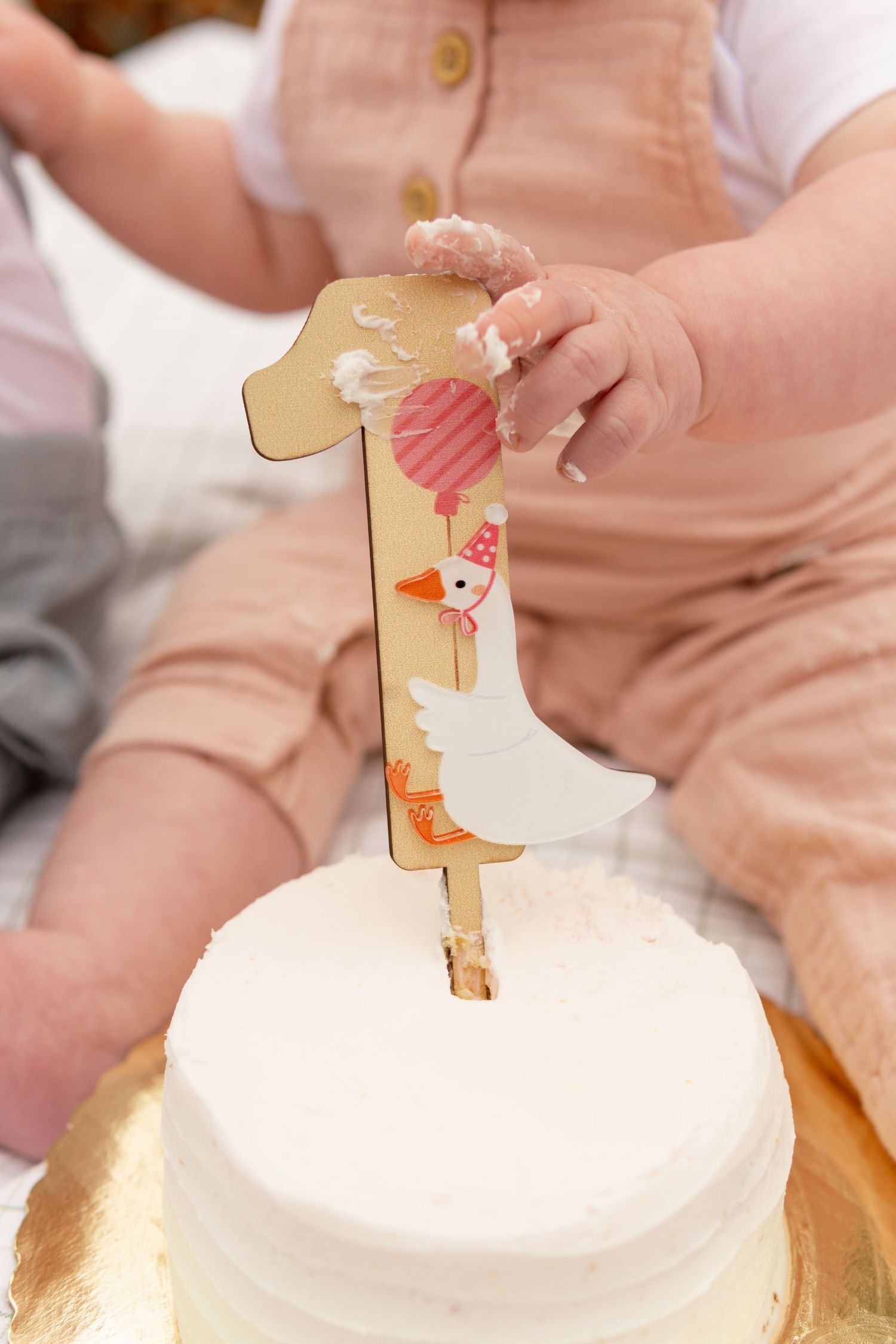 A wooden giraffe toy is gently placed on top of a soft white cushion surface.