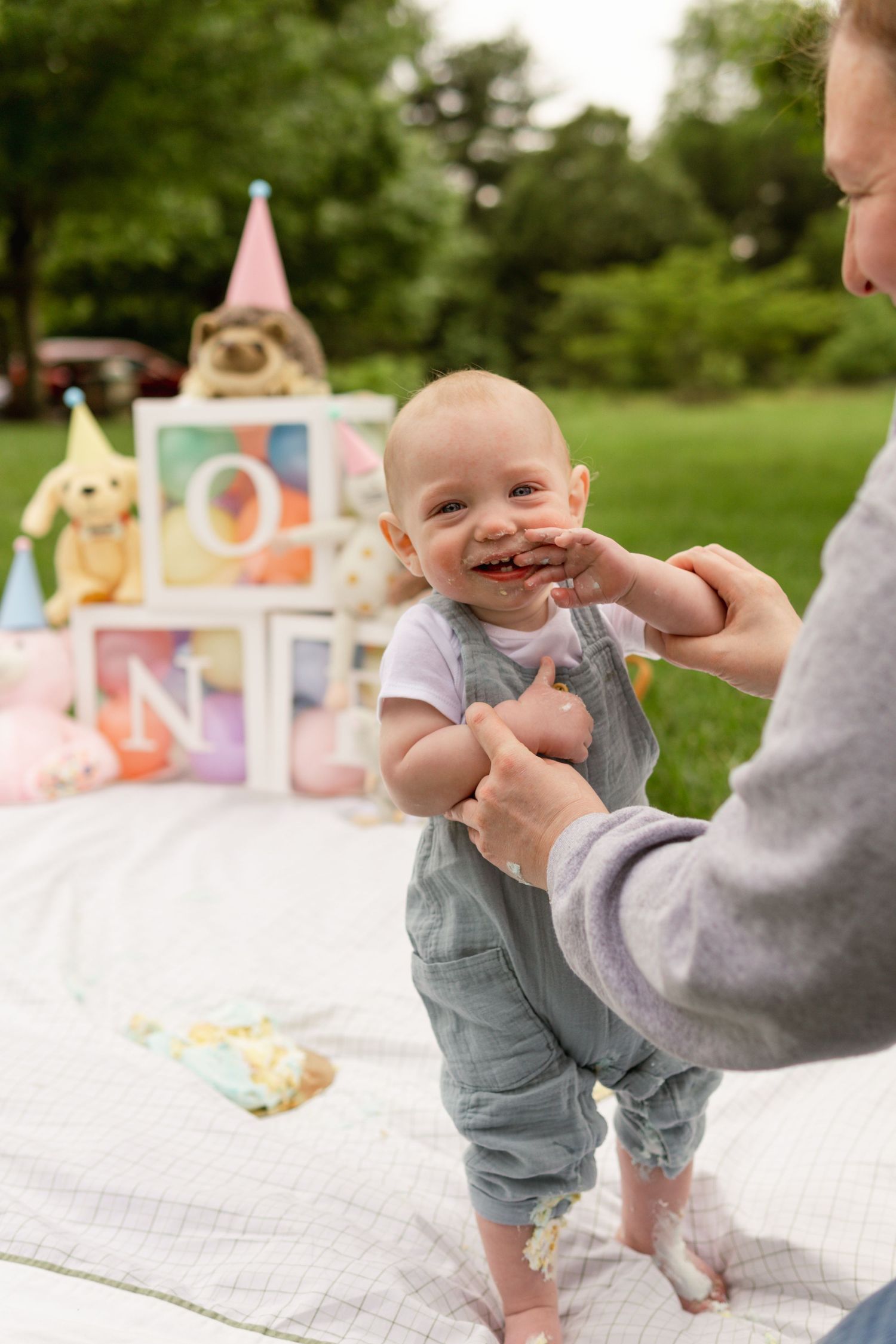 Smiling baby celebrates his cake smash session with moorestown family photographer as she captures this milestone session.