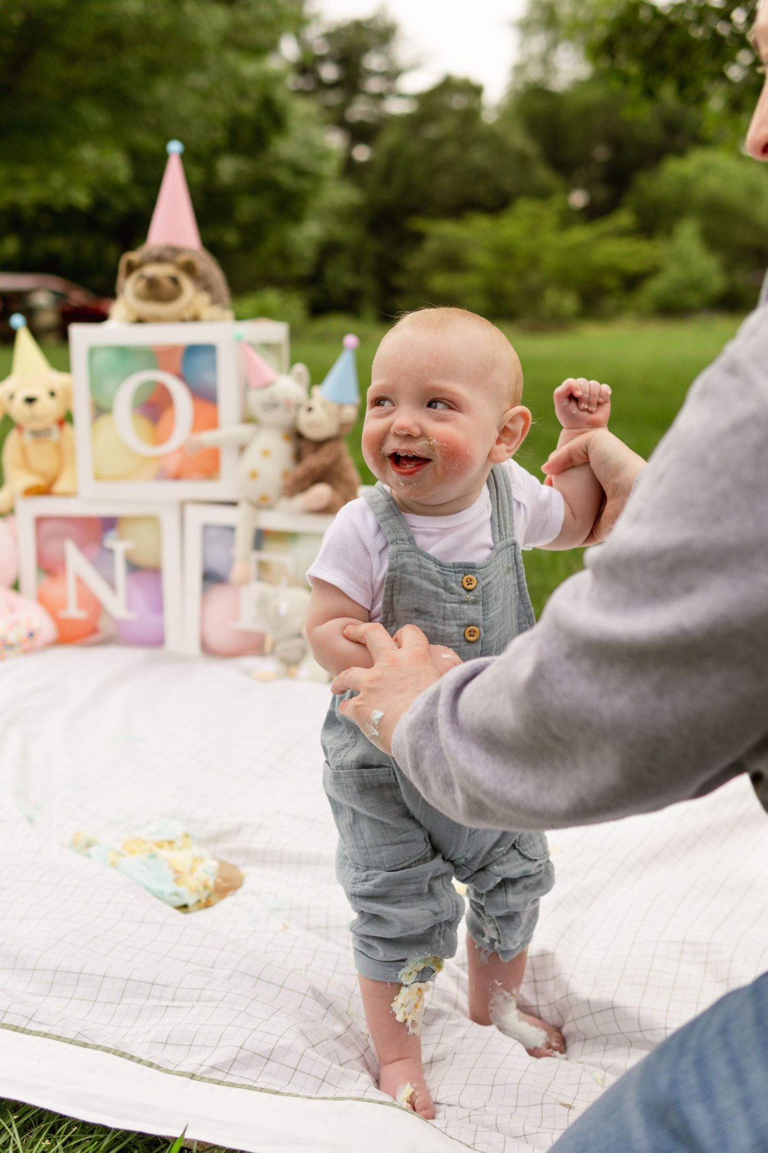 Baby smiling and playing with his mom at a cake smash photography session with cherry hill family and milestone photographer