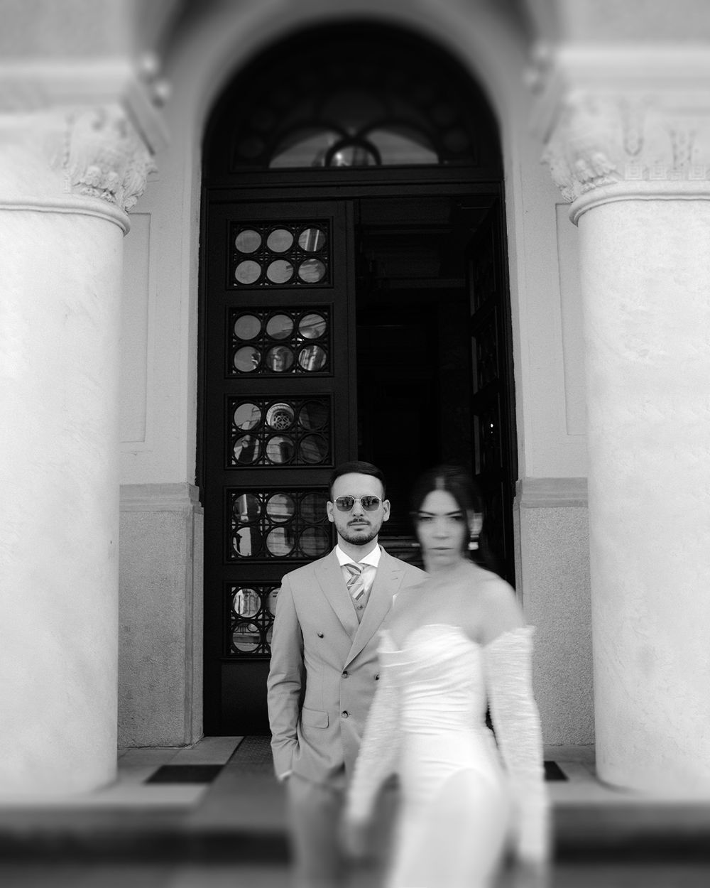 Black and white artistic wedding photos showing a couple near grand columns and doorways.