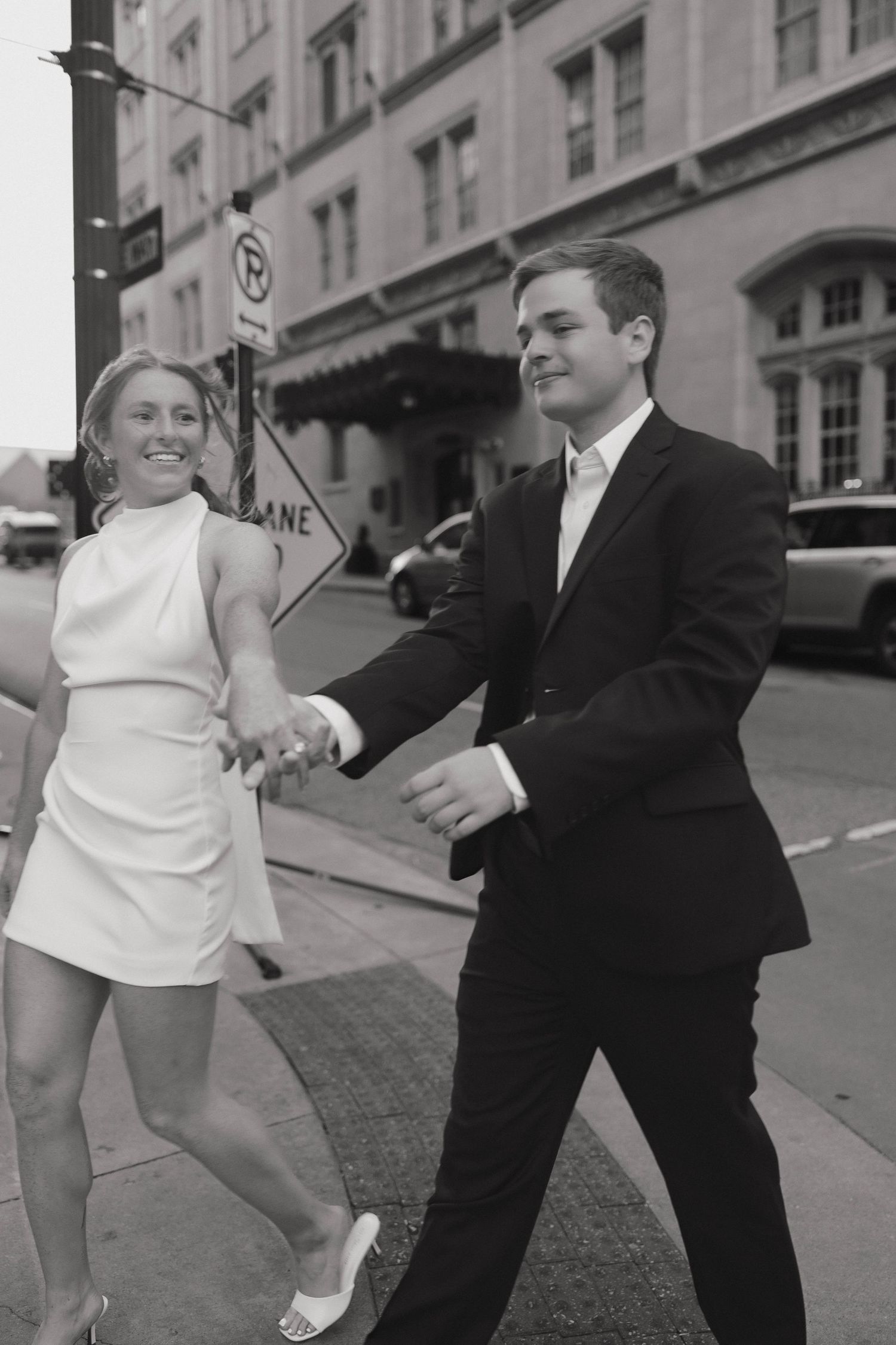 A joyful dance captured on a city street with vintage-style black and white photography.