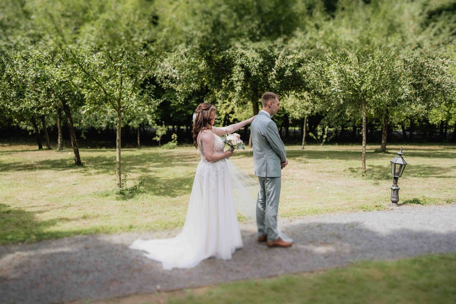 Couple having wedding photos taken in a lush green garden setting.