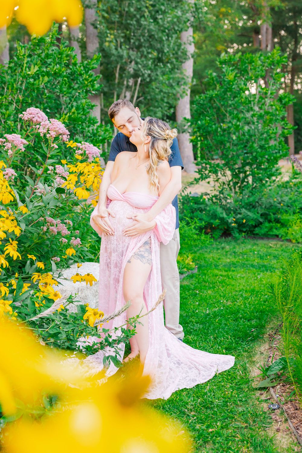 Romantic garden scene with pink dress among yellow flowers and lush greenery on a summer day.