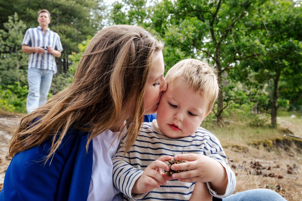 Moeder geeft haar zoontje een liefdevolle kus op zijn hoofd tijdens een gezinsshoot door Luzan Veenendaal Fotografie