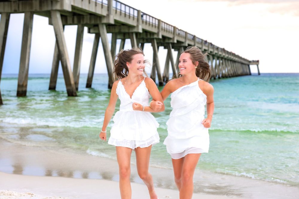 A series of oceanside family photos showing joyful moments near a pier with turquoise waters and sandy beach.