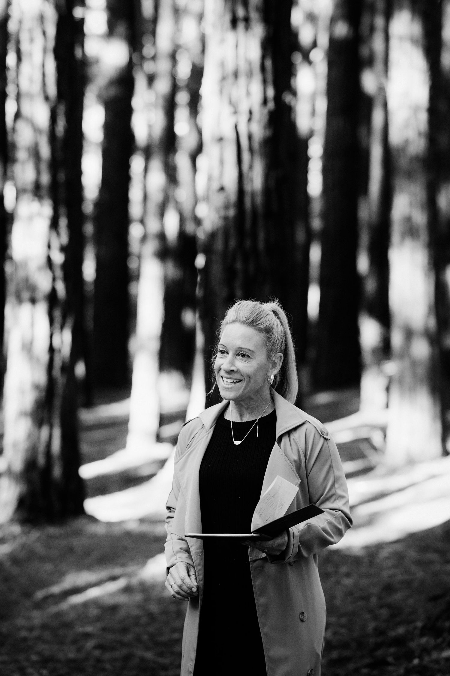 Black and white portraits of someone smiling and laughing joyfully in a sunlit forest setting.