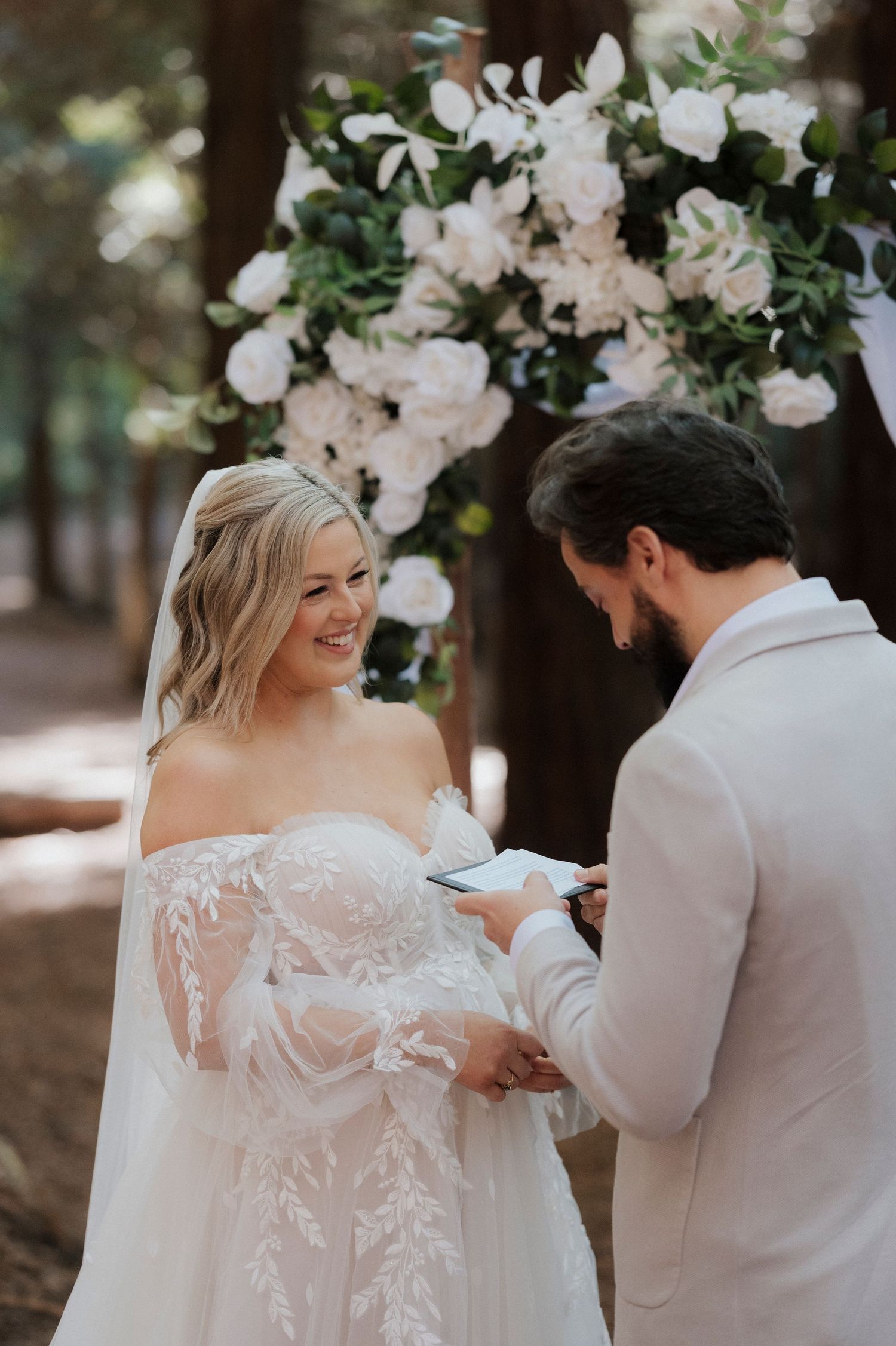 A romantic wedding first look moment with beautiful lace dress details in a serene garden setting.