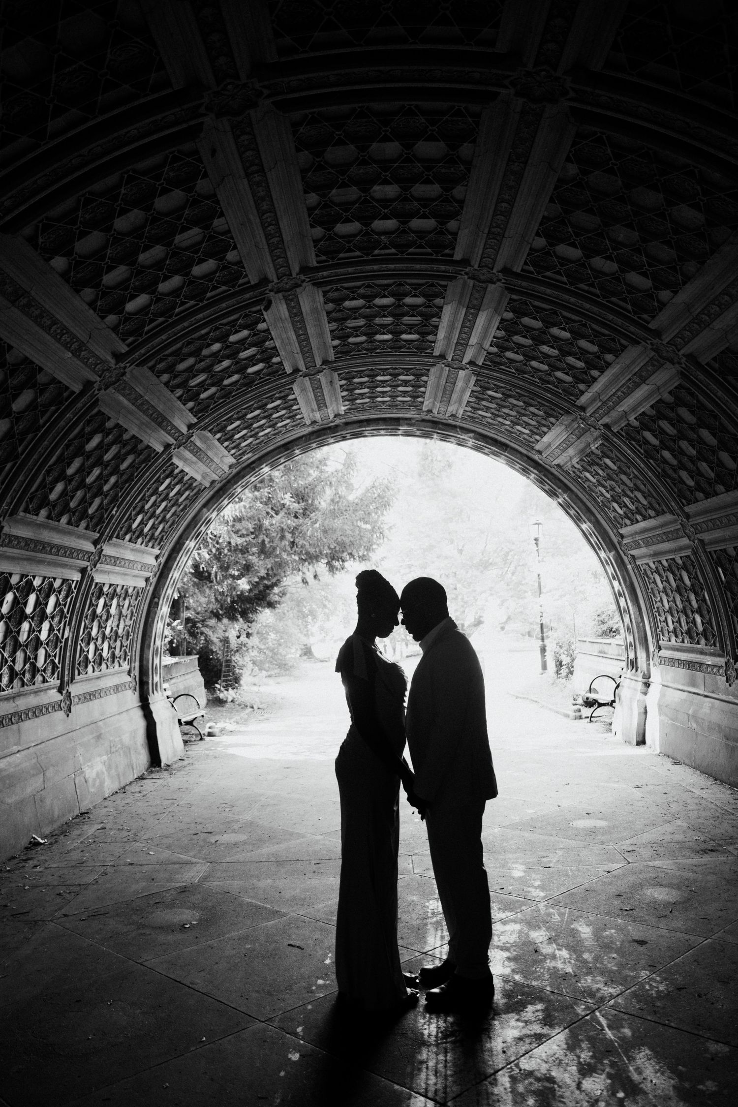 A bride and groom share a romantic kiss against a rustic wooden door background.