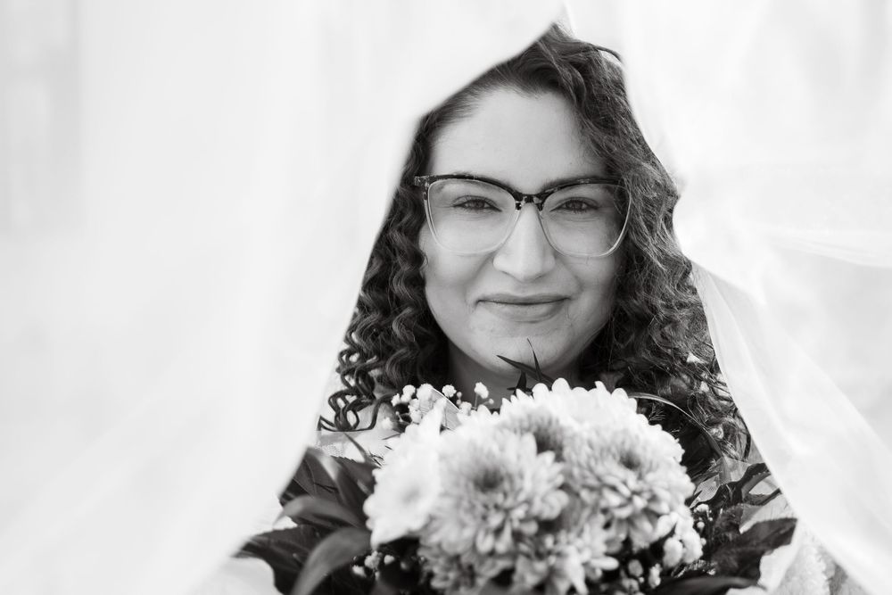 Black and white portrait with flowers and smiles in soft focus.