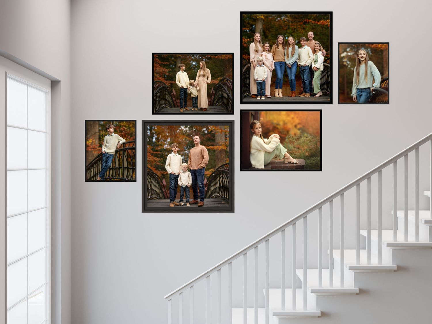 A collection of family portraits arranged on a white stairwell wall in a diagonal pattern showcases outdoor and studio photos.