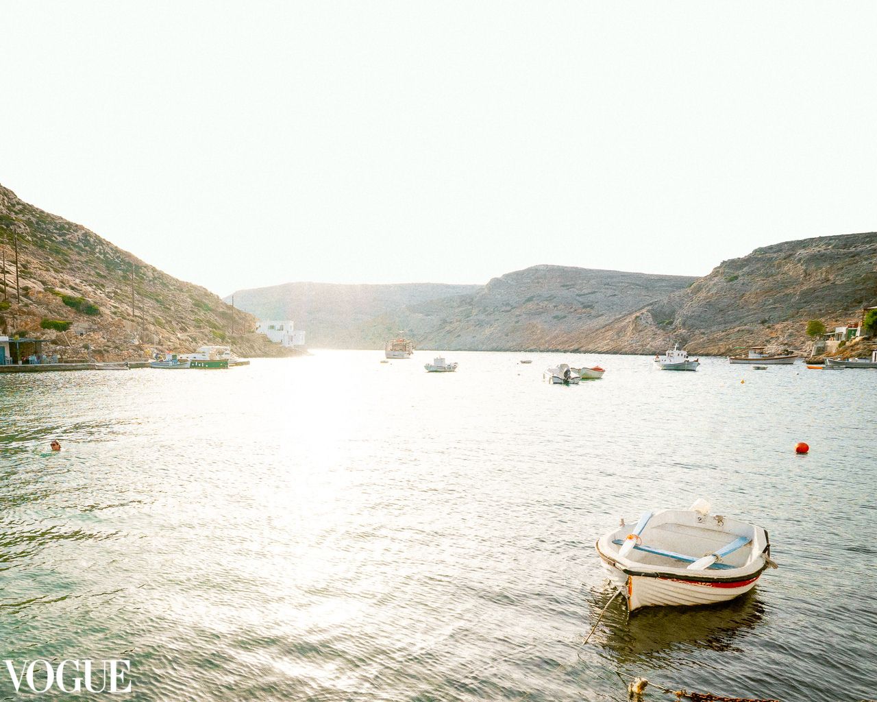 Fishing boats resting in a tranquil coastal bay under golden light