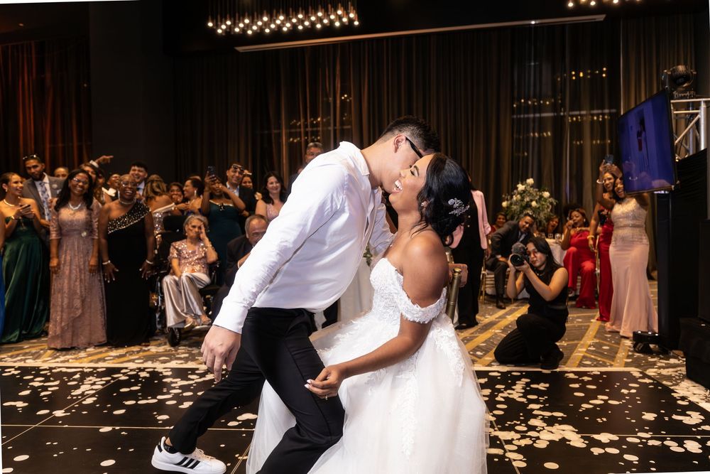 Newlyweds share a romantic dance moment on a petal-covered floor during their wedding reception.