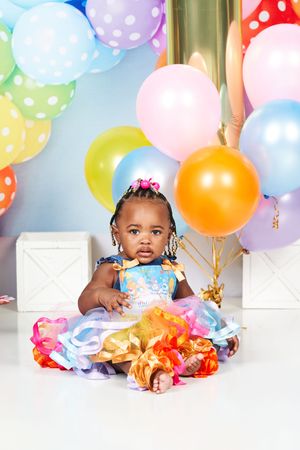 Colorful birthday party scene with festive balloons and cake decorations in pastel colors.