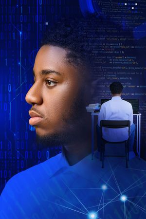 Technology professional in blue lighting against digital data visualization background showing coding and cybersecurity concepts.