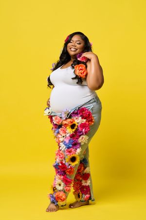 Bold fashion statement against bright yellow backdrop featuring white top adorned with vibrant floral details.