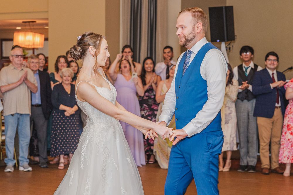 Couples dancing together at a wedding reception in a warmly lit ballroom.
