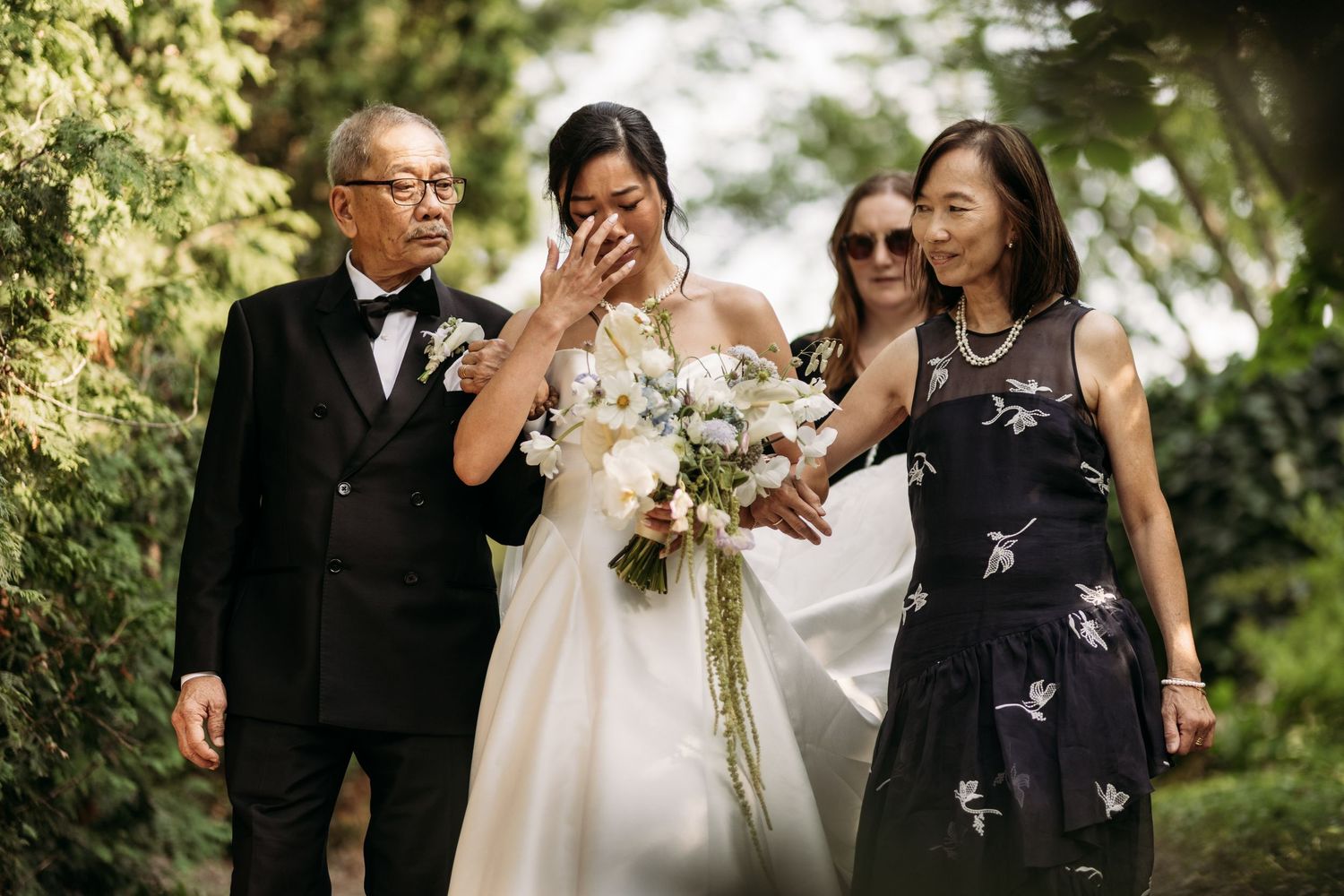 A joyful emotional moment with a wedding party laughing together in a garden setting.