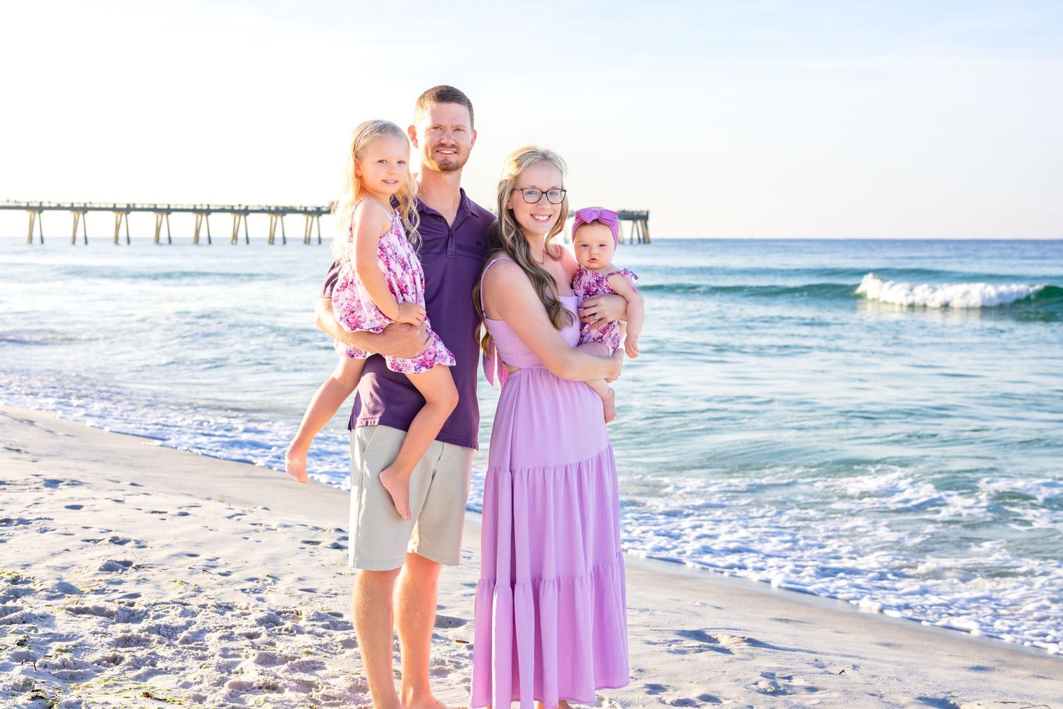 A group enjoying a sunny day at the beach with waves crashing on the shore in the background.