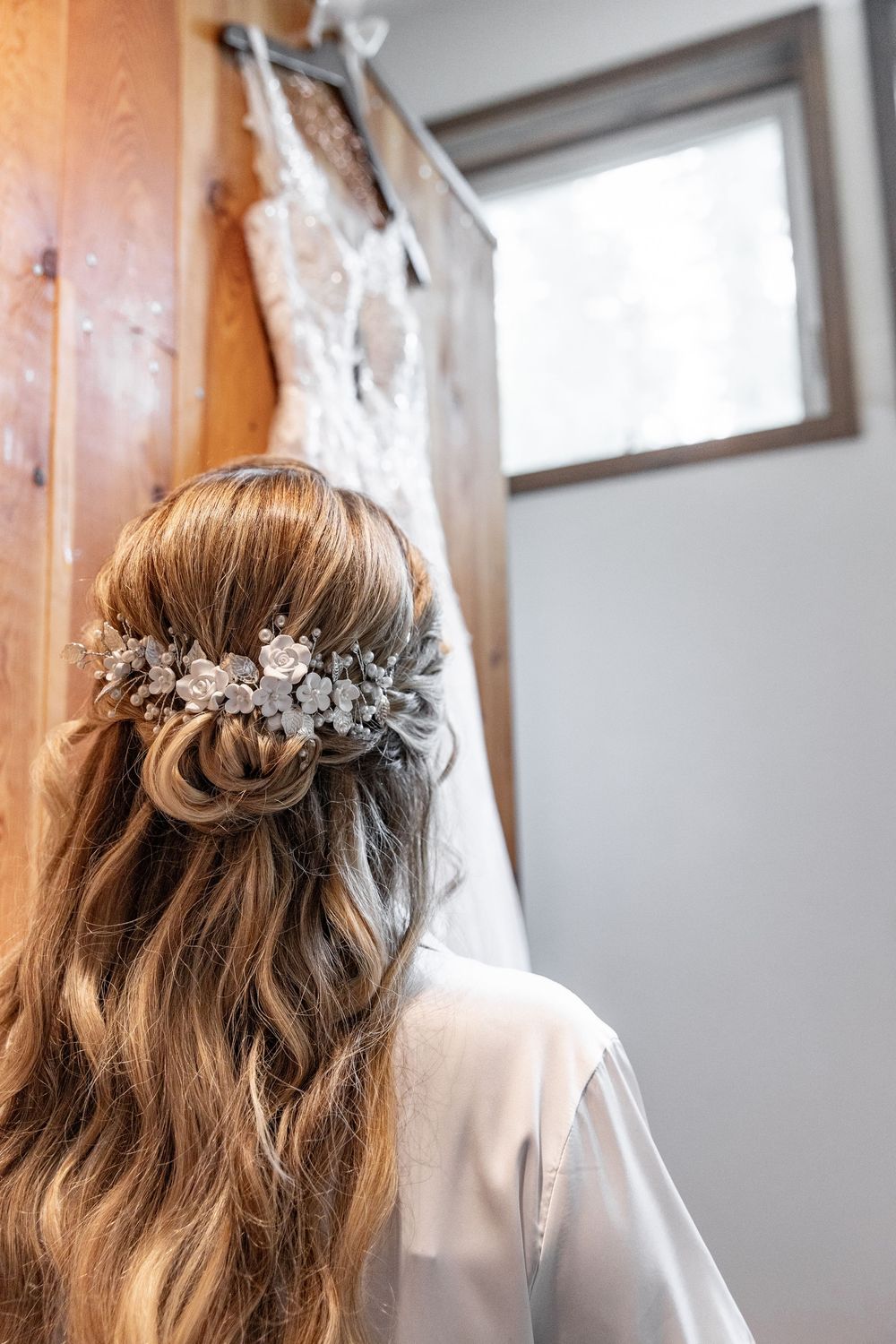 Close-up view of a delicate bridal hairstyle adorned with a crystal hairpiece in a soft waterfall braid style.