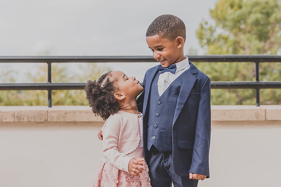 A joyful couple shares candid moments during their wedding photoshoot on a sunny outdoor terrace.