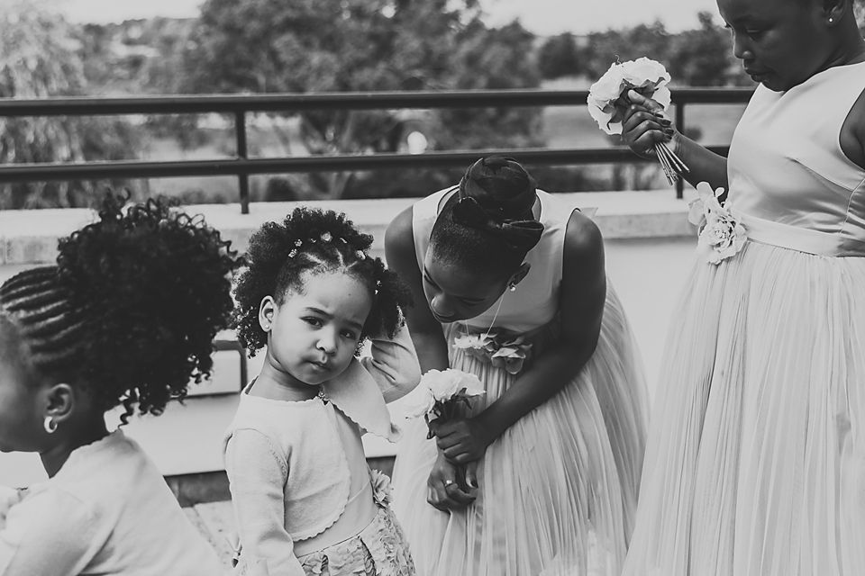 Wedding guests gathered around tables with white linens at an outdoor reception.