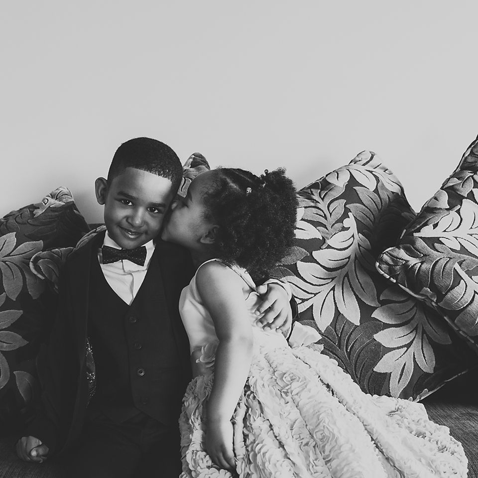 Candid black and white photo showing tender moments between wedding party members.