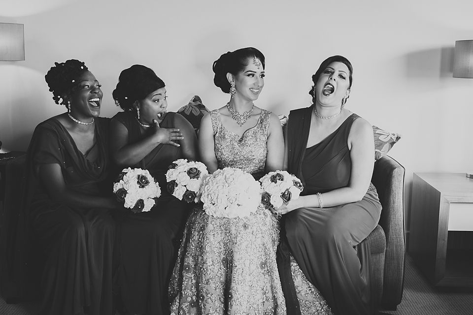 A black and white photo showing a joyful group reaction during a wedding celebration.