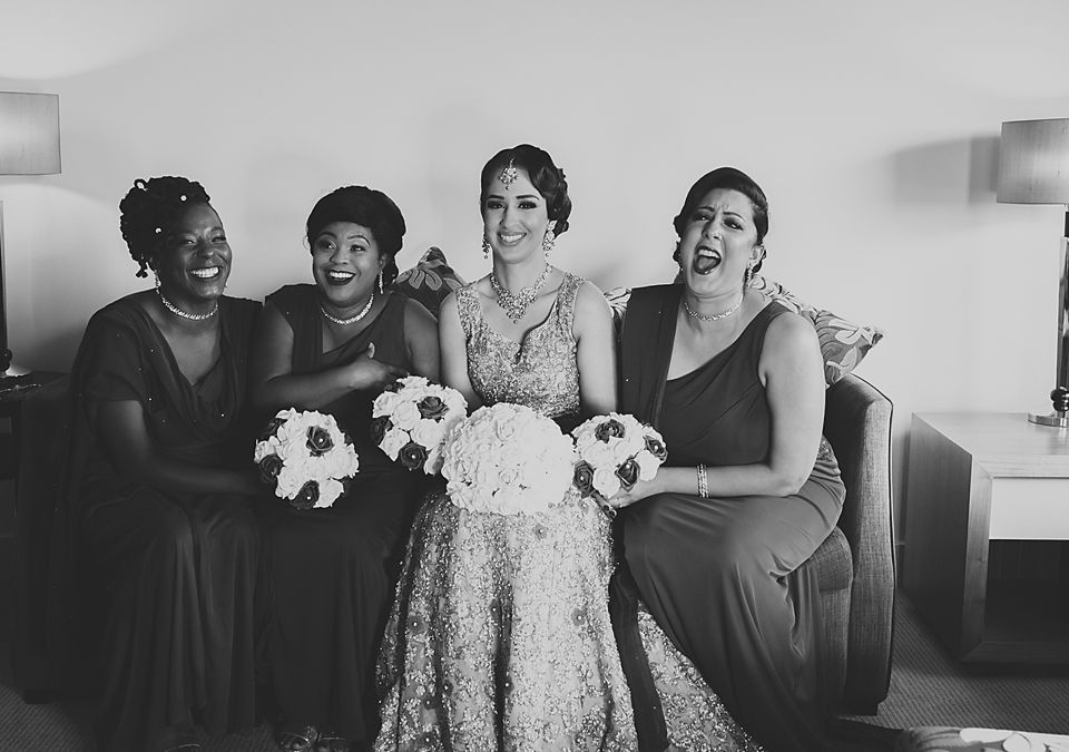 A black and white image capturing candid laughter and emotions during a wedding event.
