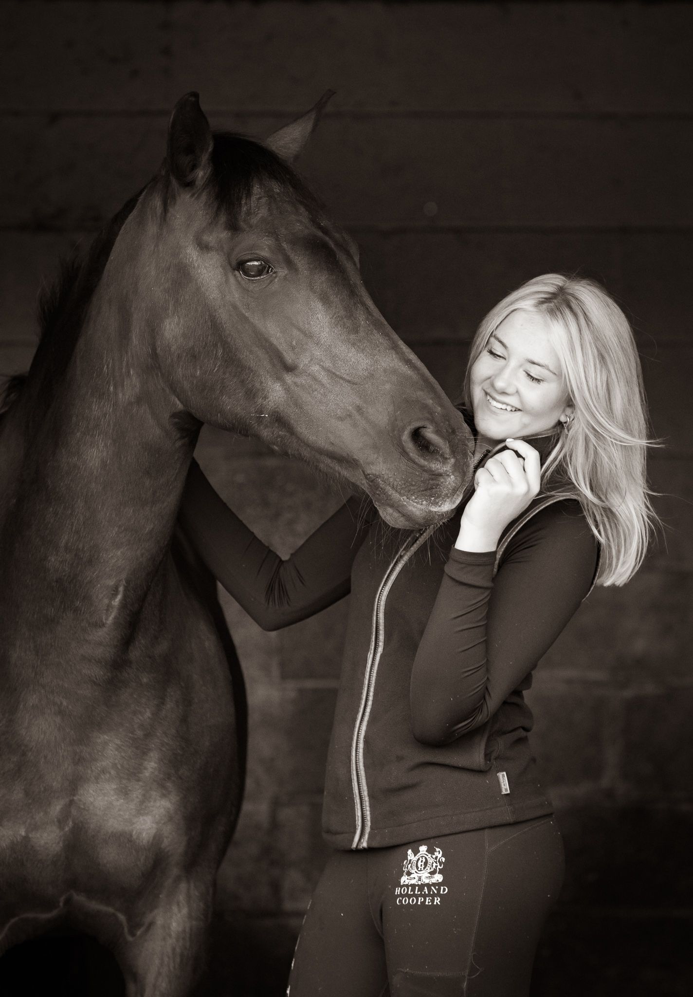 A series of black and white photographs showing tender moments between a person and a dark horse in moody lighting.