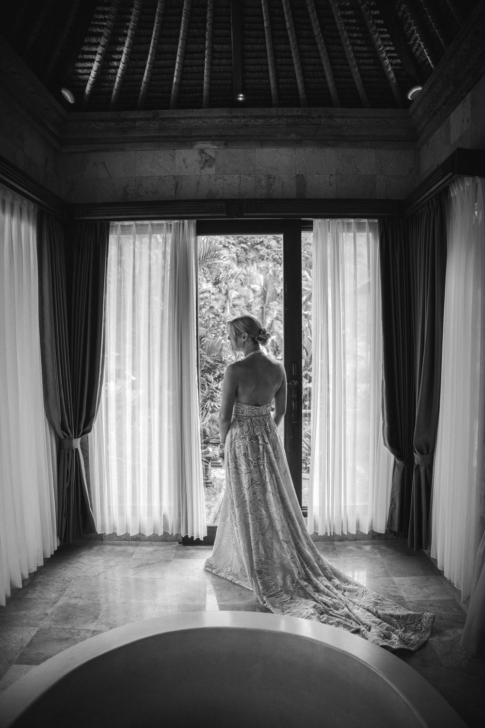 A black and white photo series showing a figure in a flowing dress silhouetted against bright windows in an elegant room.