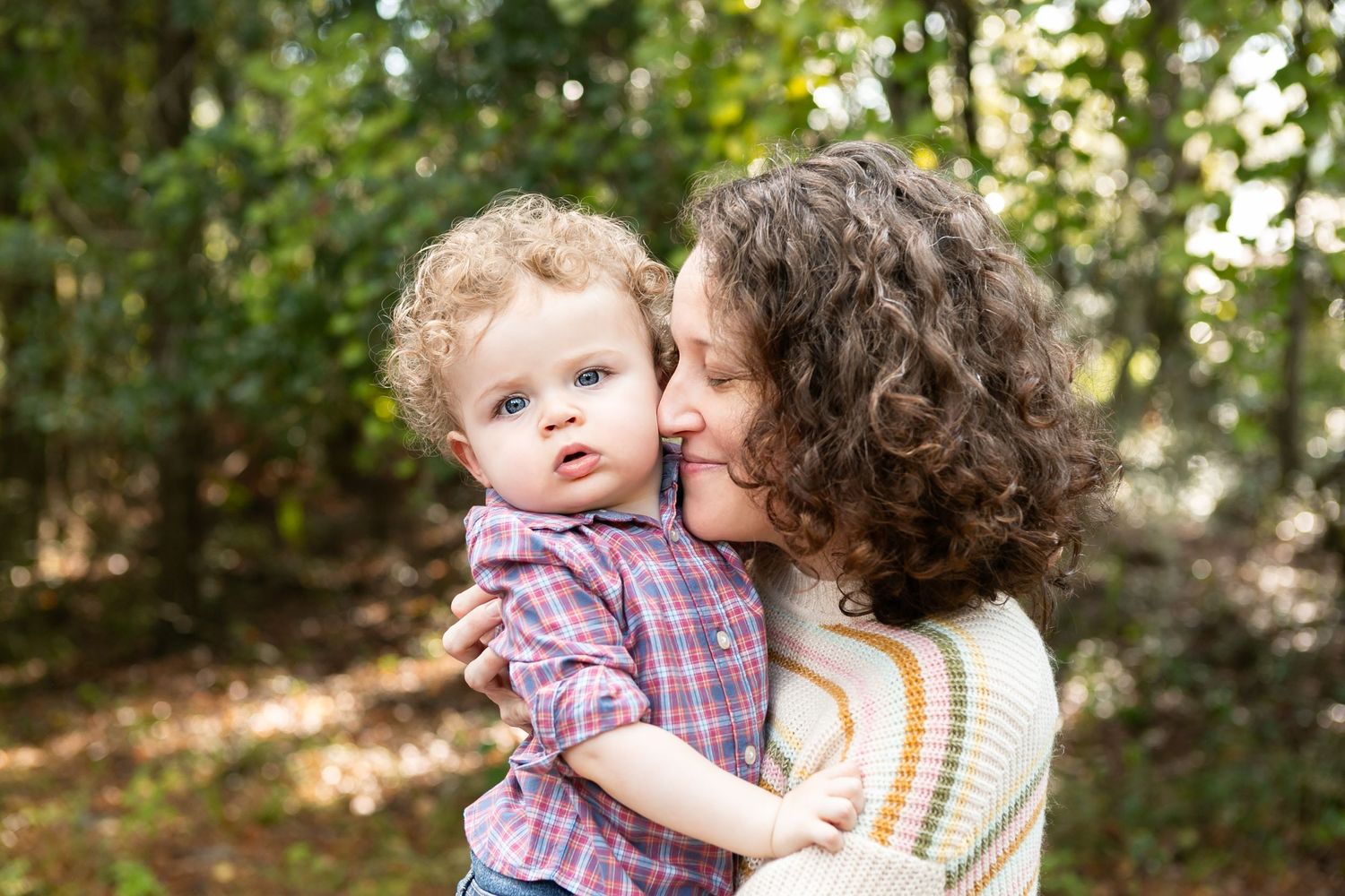 A mother and child share a tender moment outdoors. Orlando Family Photography, Sanford Family Photography