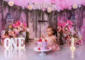 Pink floral decorations and candles create a romantic ambiance in a rustic wedding reception setting.