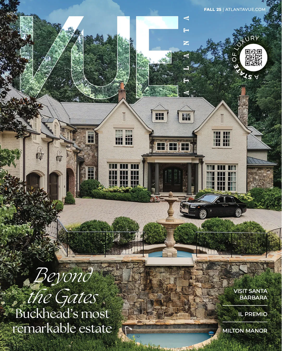 Elegant stone and stucco estate home with swimming pool, manicured gardens, and circular driveway in wooded setting.