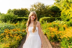 Sunlit garden path lined with bright orange marigolds and lush greenery creates a dreamy summer scene.