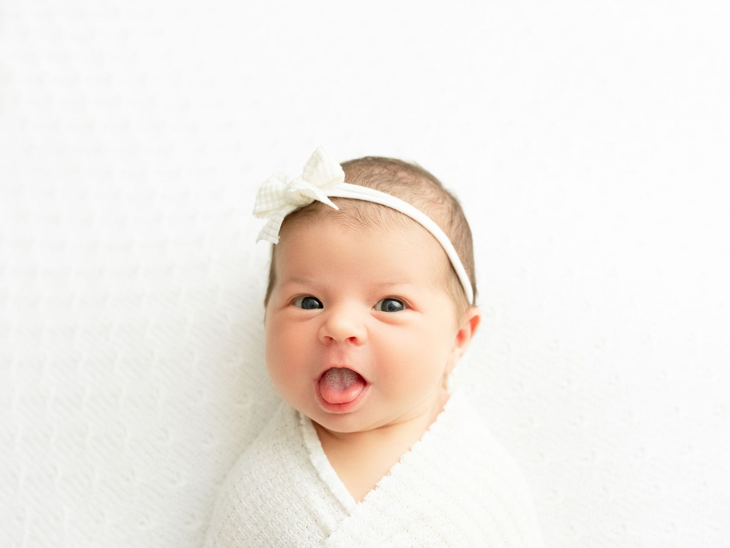 Three close-up portraits of a smiling baby wearing white against a light background.