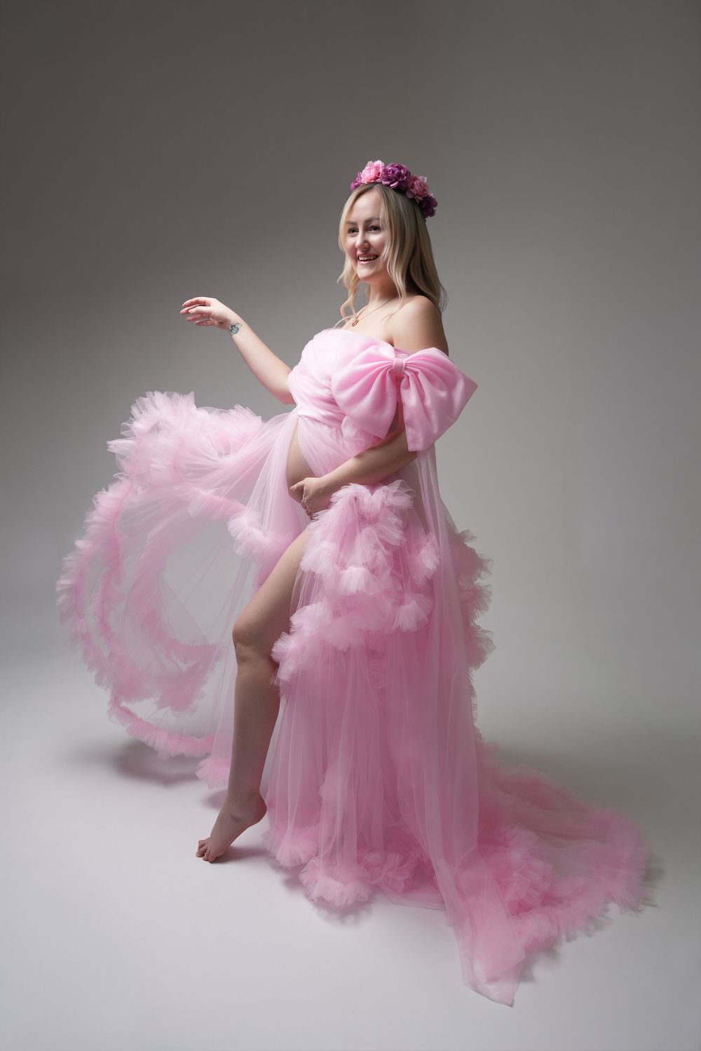 A graceful dancer in a flowing pink tulle gown performs a series of elegant poses against a gray studio backdrop.